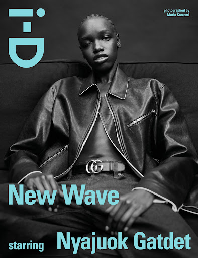Fashion magazine cover with a Black female model wearing a leather jacket, jeans, and Gucci belt against a dark grey background.
