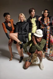 Group of five diverse models in stylish contemporary apparel posing against a plain grey studio backdrop.