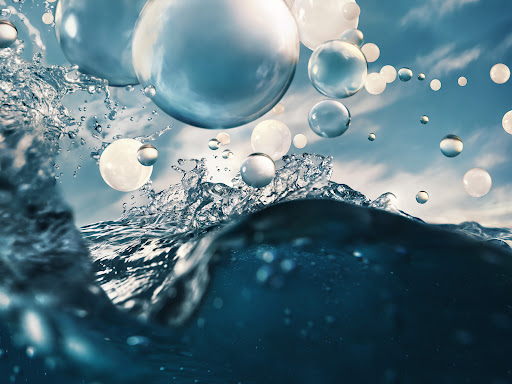 Water splash with floating spheres against a cloudy sky. Abstract visual with dynamic movement, water textures, and reflective surfaces.
