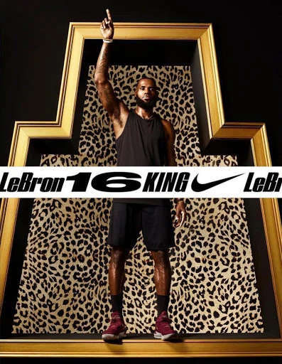 LeBron James in frame with leopard pattern and black background. He's wearing a tank top and athletic shorts, pointing upwards.