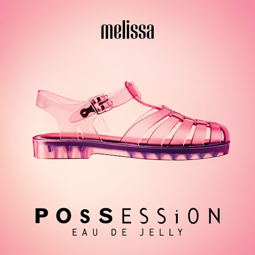 Promotional shot of a single clear jelly sandal from Melissa on a graduated pink background with Melissa brand and product name.