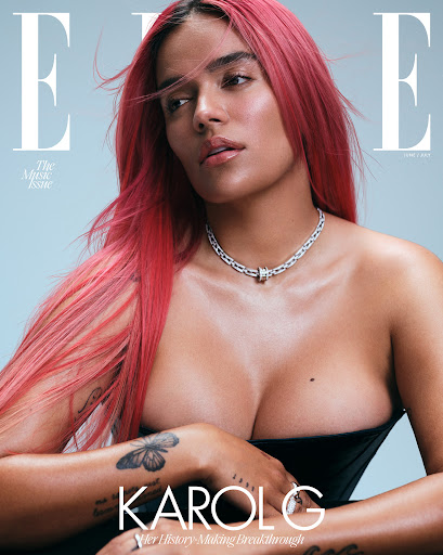 Elle magazine cover featuring Karol G with pink hair, wearing a diamond necklace and strapless top against a light blue background.