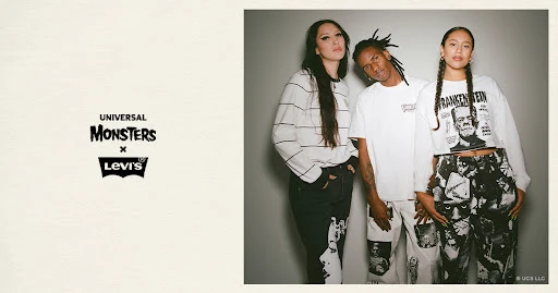 Three people model in a studio wearing Universal Monsters x Levi's branded apparel, including graphic tees and printed denim pants.