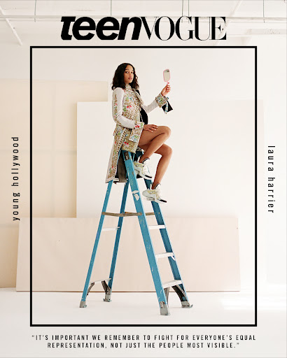 Laura Harrier poses on a blue ladder while holding a mirror, showcasing fashion for Teen Vogue in a photo studio setting with a cream backdrop.