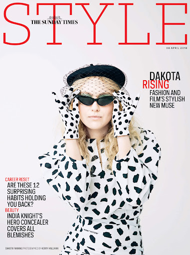 Dakota Fanning wearing a polka dot outfit and black beret with a veil against a plain white background.