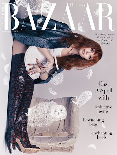 Magazine cover featuring an adult female model with auburn hair wearing thigh-high reptile-patterned boots and holding a white chair.
