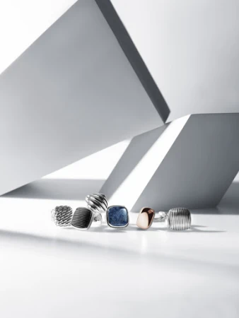 Set design still life featuring multiple silver and gemstone rings arranged on a white surface