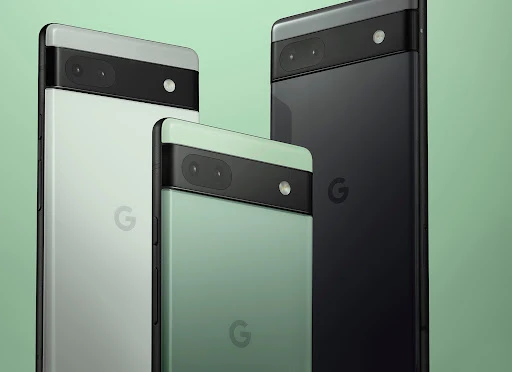 Three Google Pixel 6a smartphones in black, white, and green with a 'G' logo are presented on a light green background in a studio shot.