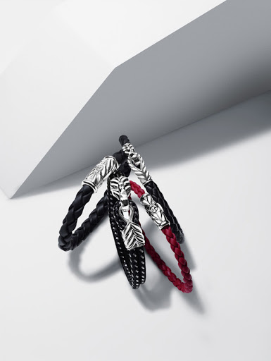 Three woven bracelets with silver leaf clasps in black, red, and dotted black, displayed on a neutral white background.