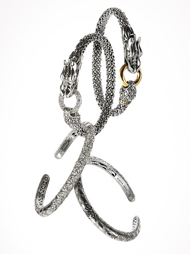Three silver and gold dragon head bracelets are interlocked in a simple arrangement against a clean, bright white background in a studio setting.