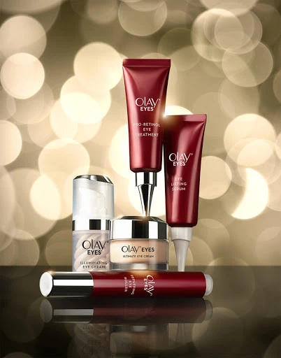 Collection of Olav Eyes skincare products including eye cream, eye lifting serum, and pro-retinol eye treatment displayed against bokeh lights.