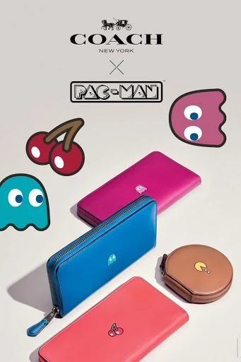 Colorful wallets featuring Pac-Man designs are displayed against a light background with Pac-Man characters and the Coach logo.