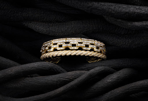 Close-up of two gold and diamond bracelets on black fabric showcasing luxury jewellery, fine craftsmanship, and elegant design.