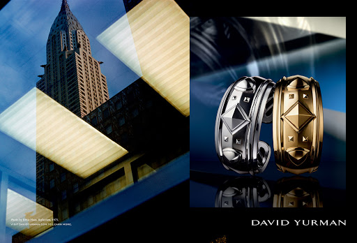 Luxury jewelry advertisement featuring two cuff bracelets with angular gemstone designs, posed against a blurred architectural backdrop.