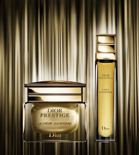 Dior Prestige skincare products in gold and glass, including La Crème Souveraine and l'Huile Souveraine, set against a textured gold backdrop.