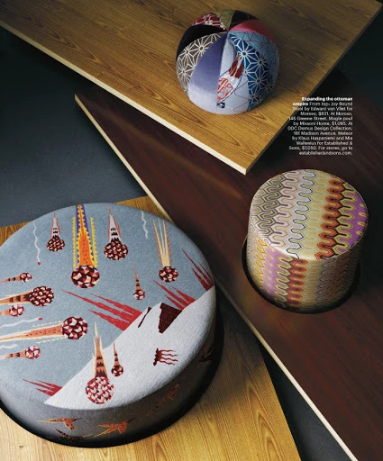 Three patterned ottomans of varying sizes and shapes are presented on geometric, wood-paneled surfaces, creating a modern furniture display.