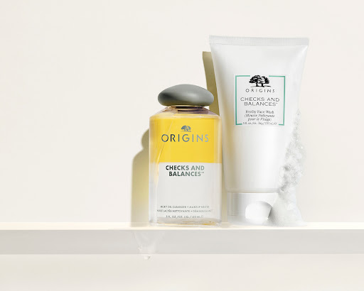 Two Origins Checks and Balances skincare products on a white shelf with white background: a cleanser and face wash.