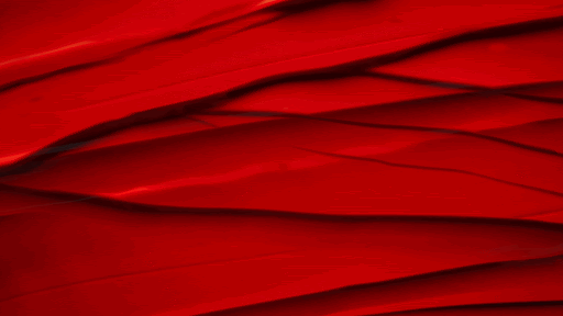 Abstract image of red fabric featuring folds and curves, creating a textured pattern with light and shadow interplay across the surface.