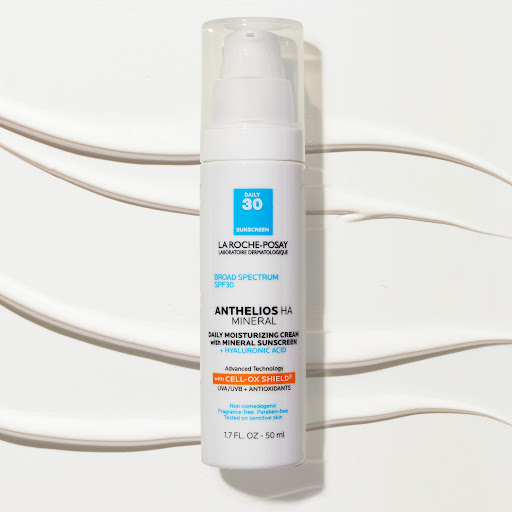 La Roche-Posay Anthelios HA Mineral sunscreen bottle with white pump dispenser on a white background with streaks of cream.
