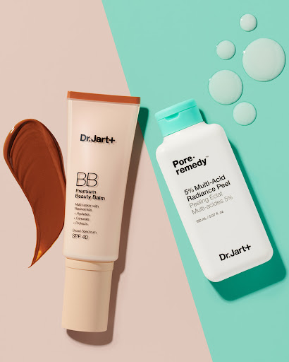 Dr. Jart+ skincare products, including BB cream and Pore-remedy radiance peel, displayed on a split pink and teal background.