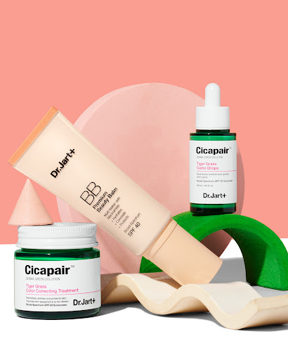 Dr. Jart+ skincare product assortment: BB cream, serum, and treatment cream on geometric props, against a peach and white background.
