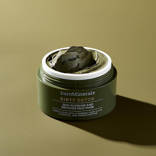Close-up shot of a green bareMinerals Dirty Detox mud mask in its container, set against a matching green background, beauty product.