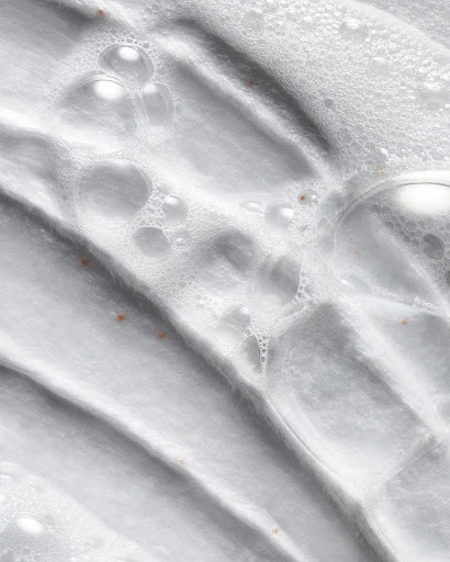 Close-up of a white textured surface with a pattern of ridges and valleys covered with a layer of transparent bubbles of varying sizes.
