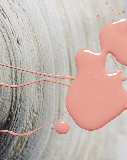 Abstract close-up of peach-colored paint blob with drips on textured white surface, creating an artistic and visually interesting composition.