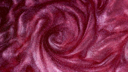 Swirling texture of pink and maroon with a glittery effect, creating a mesmerizing, abstract background ideal for beauty or design projects.