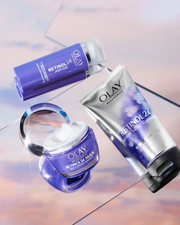 Olay Retinol 24 MAX moisturizer, Retinol 24 + Peptide serum, and Retinol Facial Cleanser arranged on a reflective surface.
