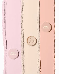 Three vertical stripes of pastel coloured face powder swatched on a white background with product lids.