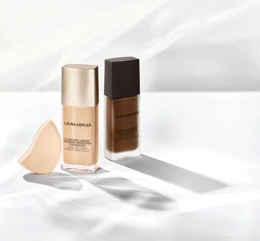 Laura Mercier Flawless Lumiere Radiance Perfecting Foundation in two shades with makeup sponge, studio shot with window light.