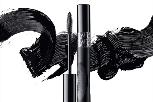 Dior mascara tube and wand with a black lash-thickening product stroke on a white background, showcasing a beauty product shot.