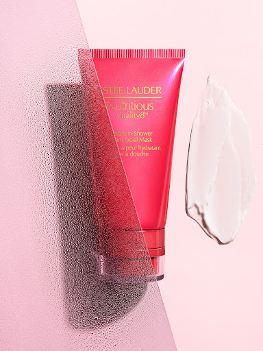 Estee Lauder Nutritious Vitality8 facial mask in pink packaging with a white cream swatch against a pink and white backdrop.
