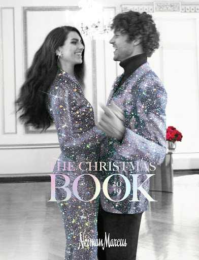 Magazine cover featuring a smiling couple in sparkling jackets dancing in a room with a chandelier, promoting a Christmas book from Neiman Marcus.