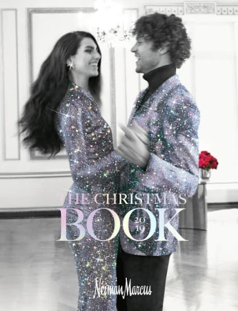 Magazine cover featuring a smiling couple in sparkling jackets dancing in a room with a chandelier, promoting a Christmas book from Neiman Marcus.