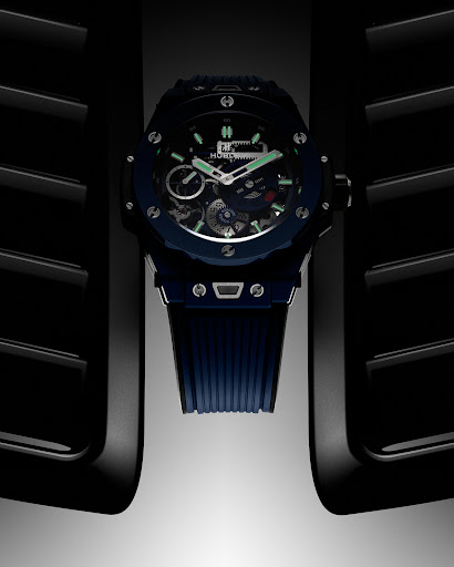 Close-up studio shot of a black and blue Hublot wristwatch with a skeleton dial, showcasing its intricate inner workings and design.