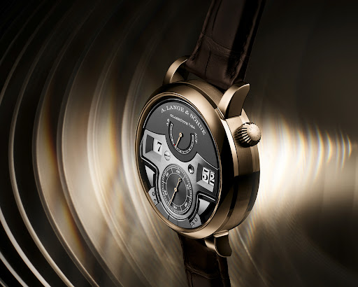 Luxury wristwatch with a brown leather band and golden details, showcased in a studio setting with blurred, ribbed background elements.