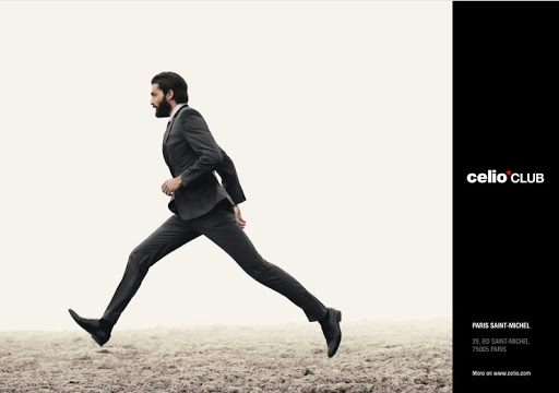 Man in suit leaps across a dirt field in a fashion advertisement, Celio Club logo on a black bar to the right side.