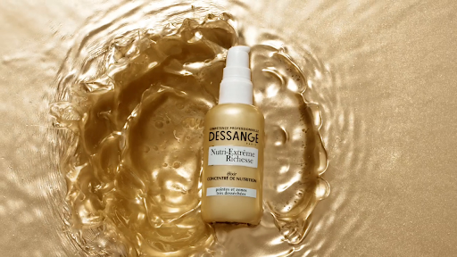 DESSANGE Paris Nutri-Extrême Richesse elixir bottle stands out against a rippled gold background, showcasing luxurious hair nutrition.