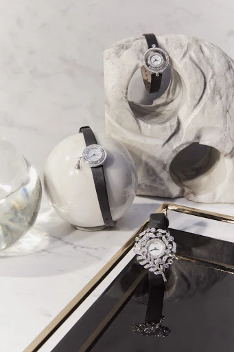 Elegant timepiece product shot. Wristwatches with black leather straps displayed on geometric white marble, marble background, studio lighting.