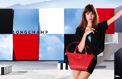 Longchamp handbag commercial featuring a female model holding a red leather handbag against a Mondrian-style wall with the brand logo.