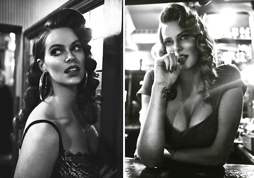 Black and white portrait of two adult women with retro hairstyle and makeup, posing indoors, in a vintage style reminiscent of old Hollywood.