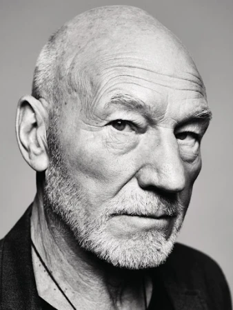 Close-up monochrome portrait of Patrick Stewart with a serious expression against a grey background.