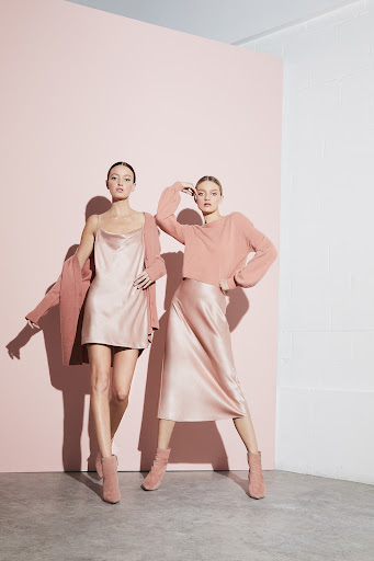 Two female models in pink satin slip dress and midi skirt posing in studio by Jessi Butterfield