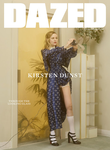 Magazine cover featuring Kirsten Dunst in a blue patterned dress, holding a camera, with the magazine's name 'Dazed' at the top.