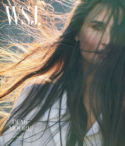 Demi Moore cover shoot for WSJ. Magazine with long dark hair blowing across her face, wearing a white blouse in outdoor lighting.