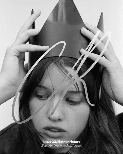 Black and white portrait of a young woman with a crown on her head and dramatic lighting, focusing on her face and hands.