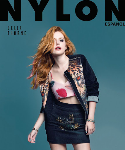 Magazine cover featuring Bella Thorne with red hair wearing a floral crop top, a jacket with tiger print, and a black skirt against a blue background.