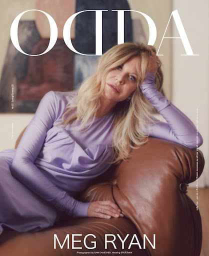 Magazine cover featuring Meg Ryan in a lilac dress, reclining on a brown leather couch against an abstract painting background.